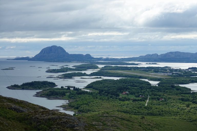 Torghatten, a mountain with a large hole through it, seen behind Brønnøysund Airport from a hill north of the town.