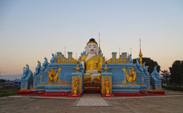 Photo of white Buddha at a blue temple complex at Inle Lake, Myanmar.