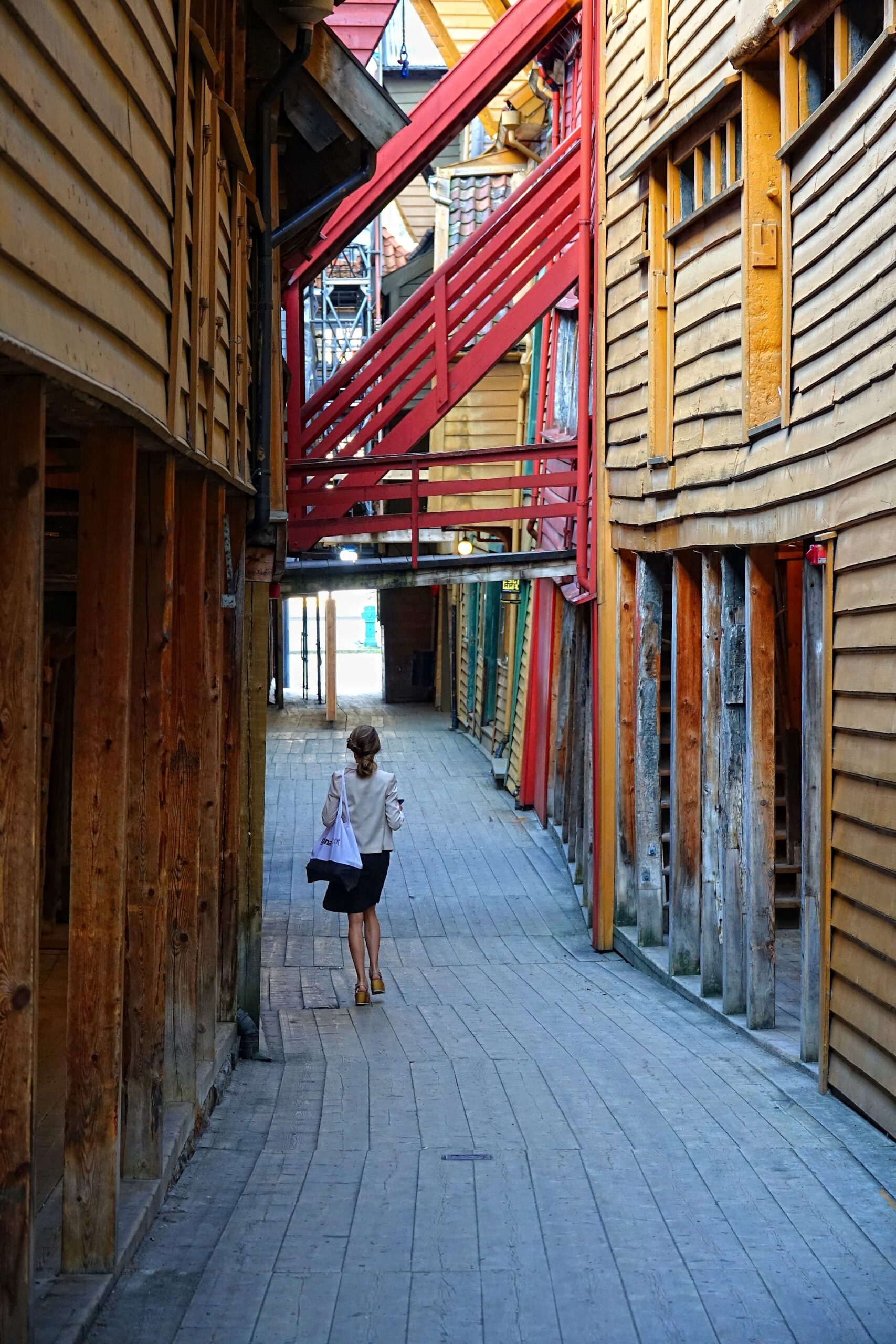 Photo of woman walking through Bryggen, Bergen.