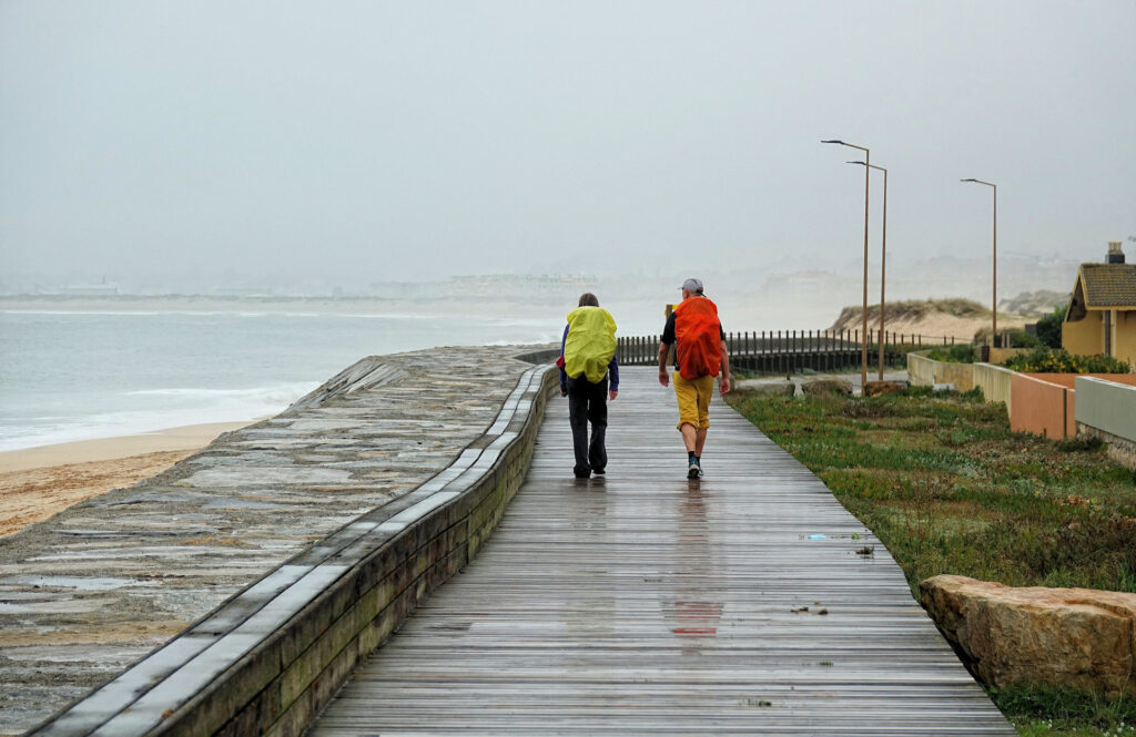 Photo of two pilgrims walking past Mindelo on the Coastal Route of Caminho Portugues.
