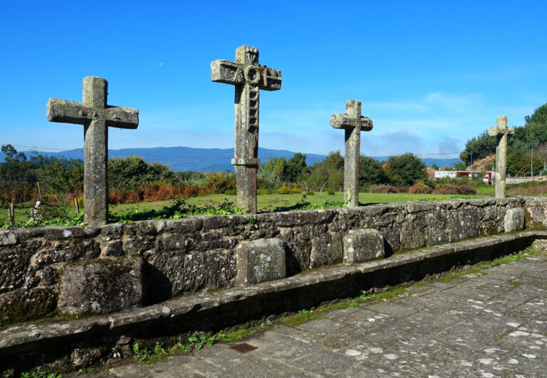 Photo of old stone crosses outside a church in Valga, Spain.