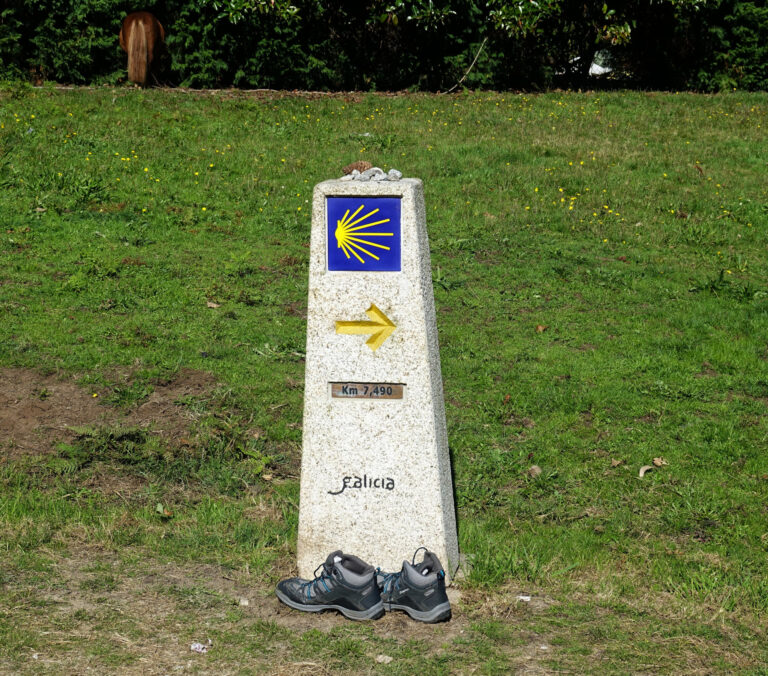 Photo of shoes left behind at a distance marker on the Camino de Santiago, Spain.