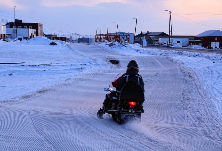 Photo of snowmobile riders in Longyearbyen at night