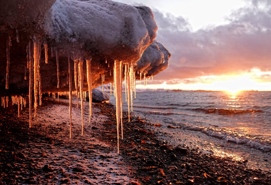 Photo of icicles colored red by the setting sun